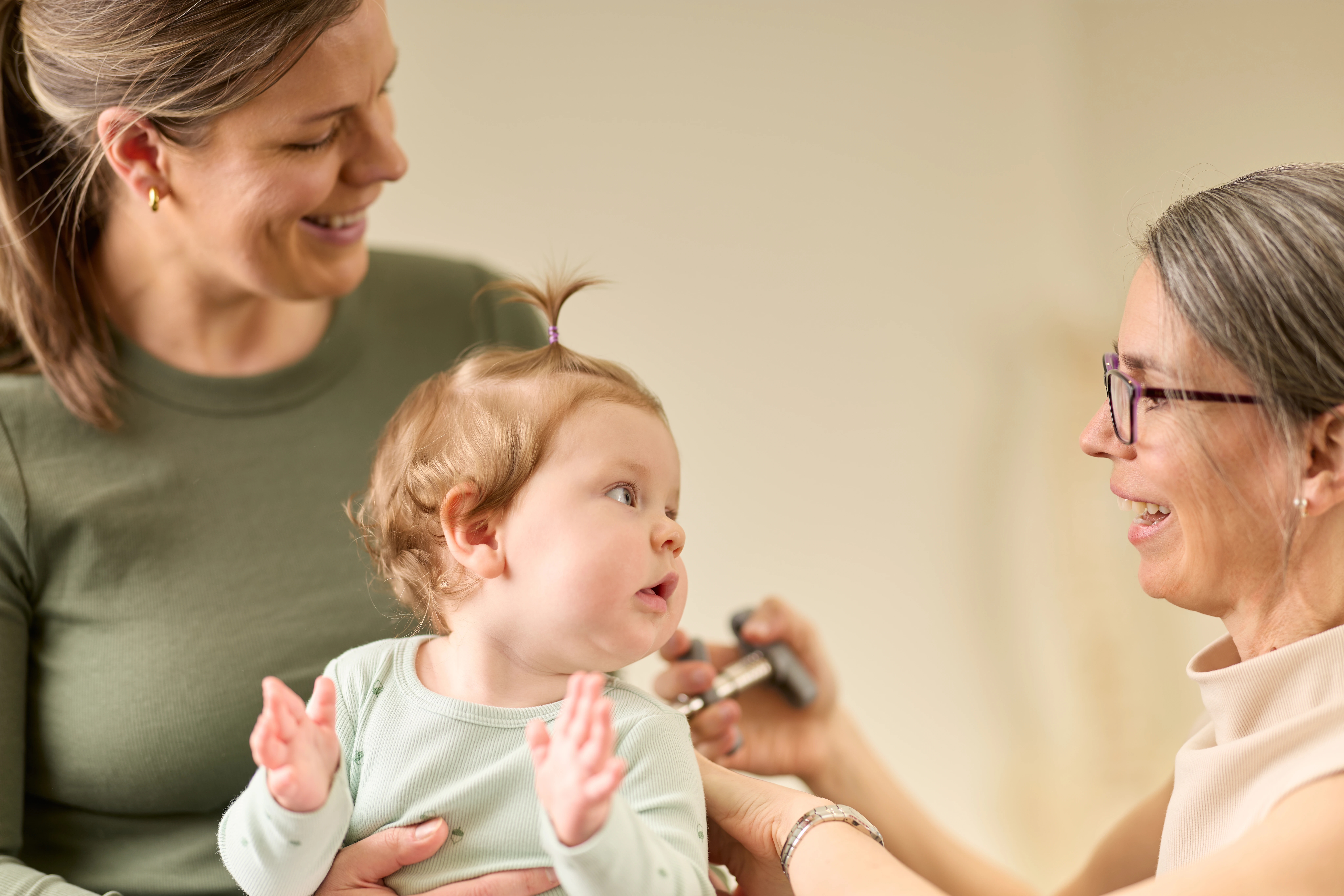 A young baby on her mother's lap receiving a chiropractic treatment from Dr Adrienne Wilson, chiropractor Norwood Adelaide